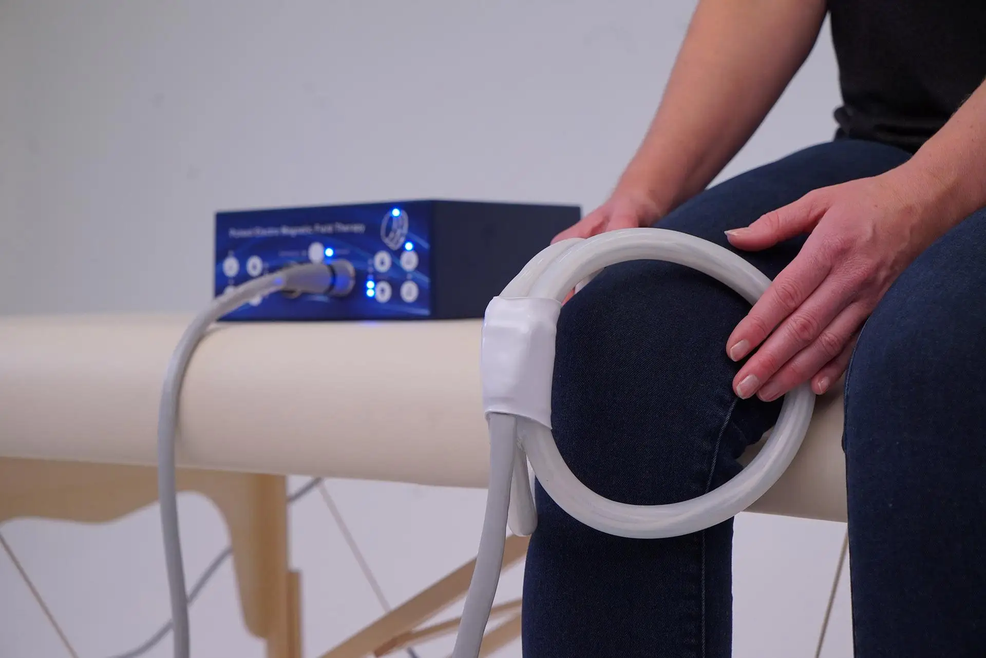 PEMF device with coil around seated patient's knee
