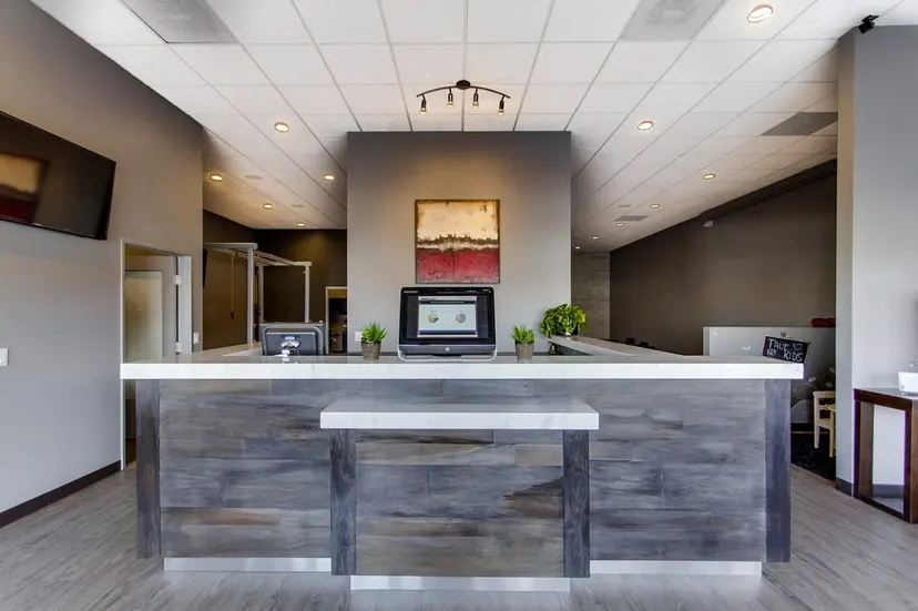 Clinic reception desk with wood panelling at True Chiropractic